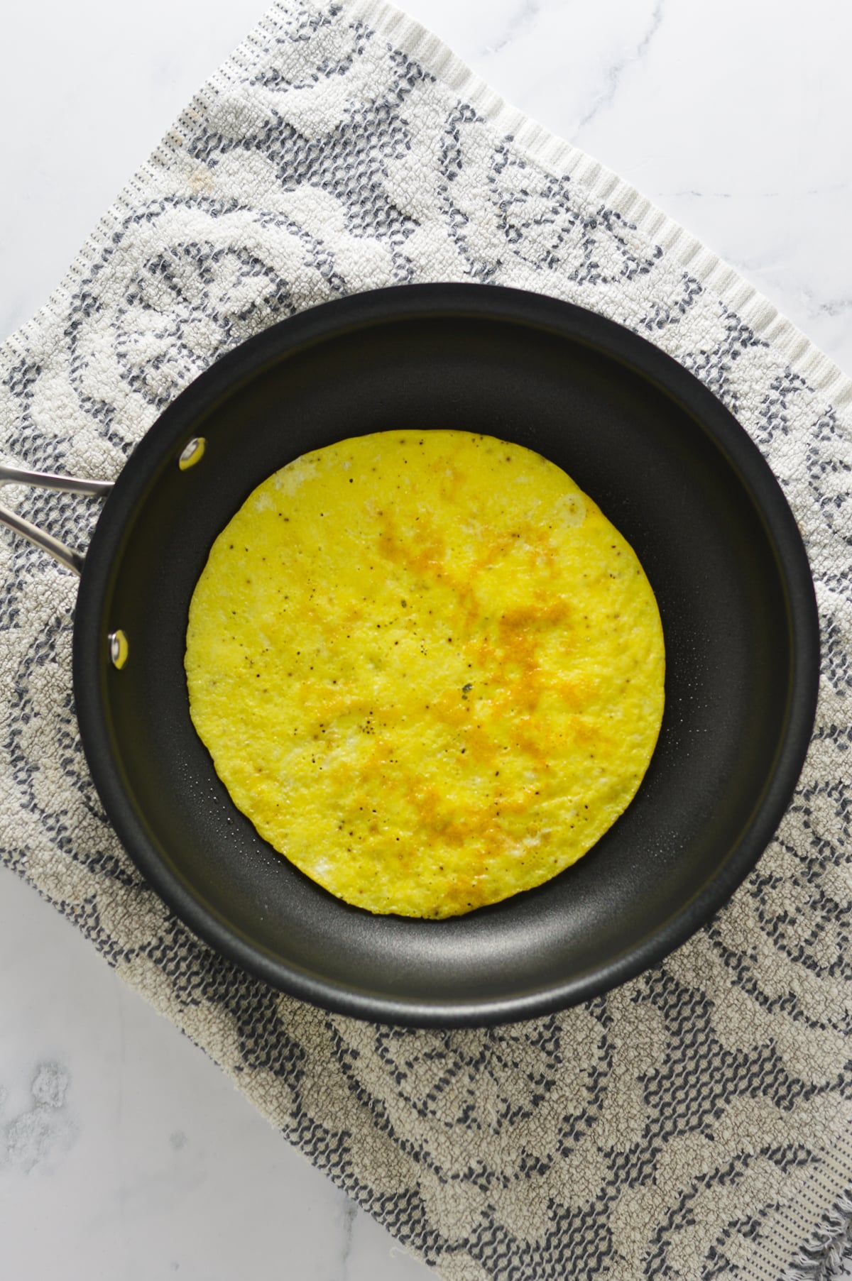 A golden brown cooked egg in a small skillet.