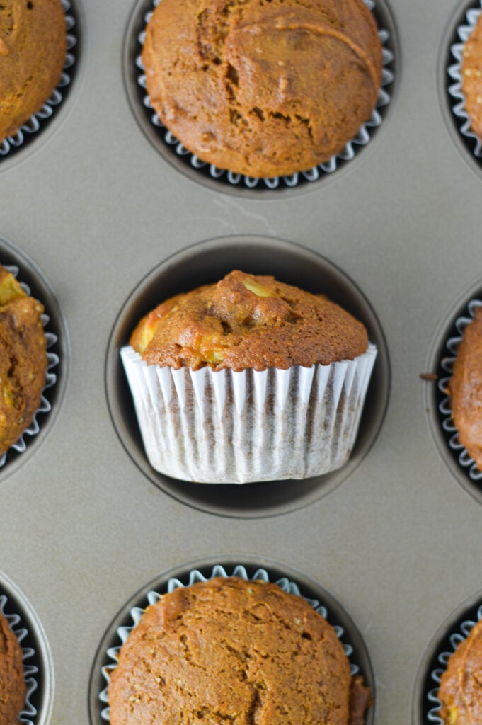 A muffin pan with freshly baked Apple Pumpkin Muffins.