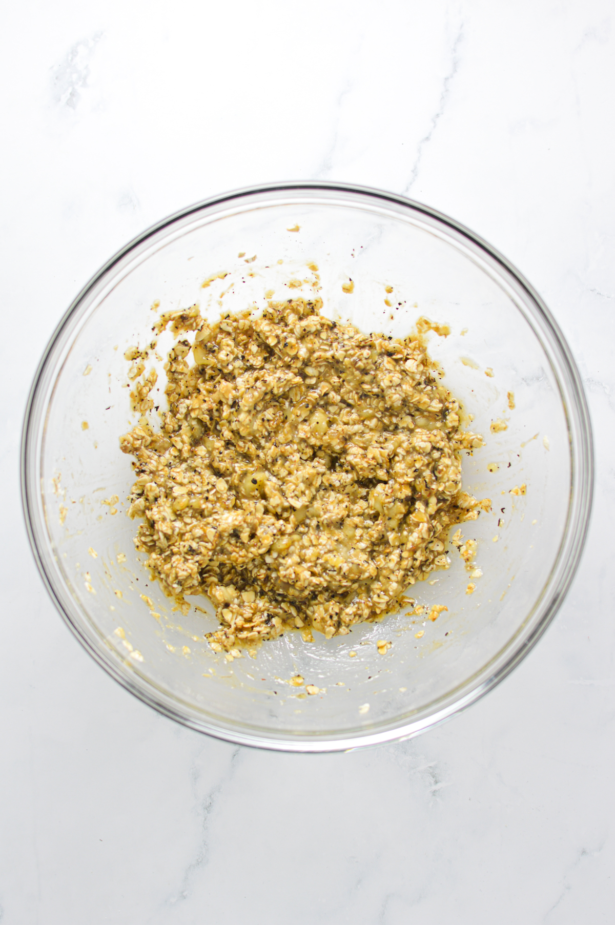 The banana, quick oats, chai latte, instant coffee, vanilla, and white sugar mixed together in a medium bowl.
