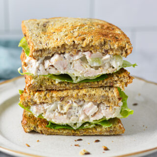 A Chicken Salad Sandwich cut in half, showing the toasted bread stuffed with creamy chicken salad.
