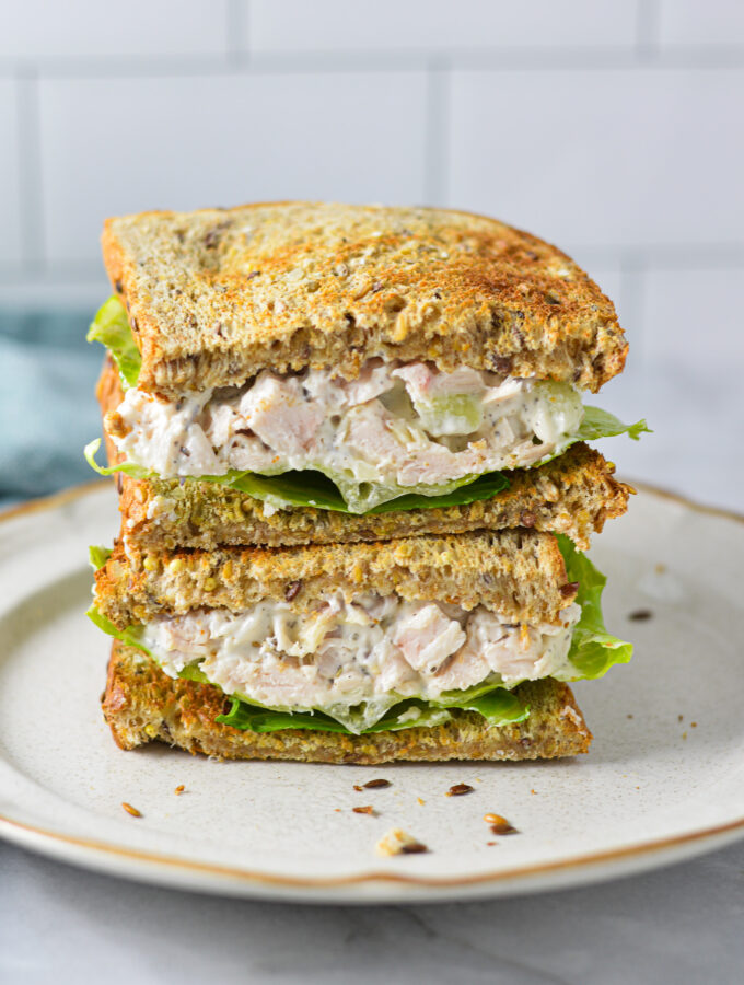 A Chicken Salad Sandwich cut in half, showing the toasted bread stuffed with creamy chicken salad.