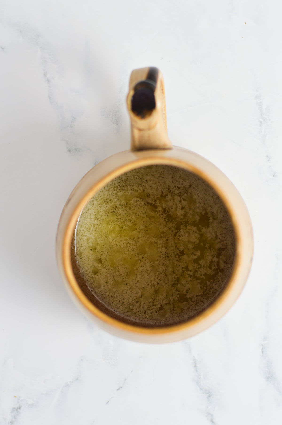 Some melted butter in a large coffee mug.