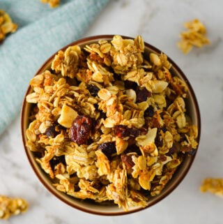 A bowl full of large clusters of homemade Sweet and Salty Coconut Vanilla Bean Granola.