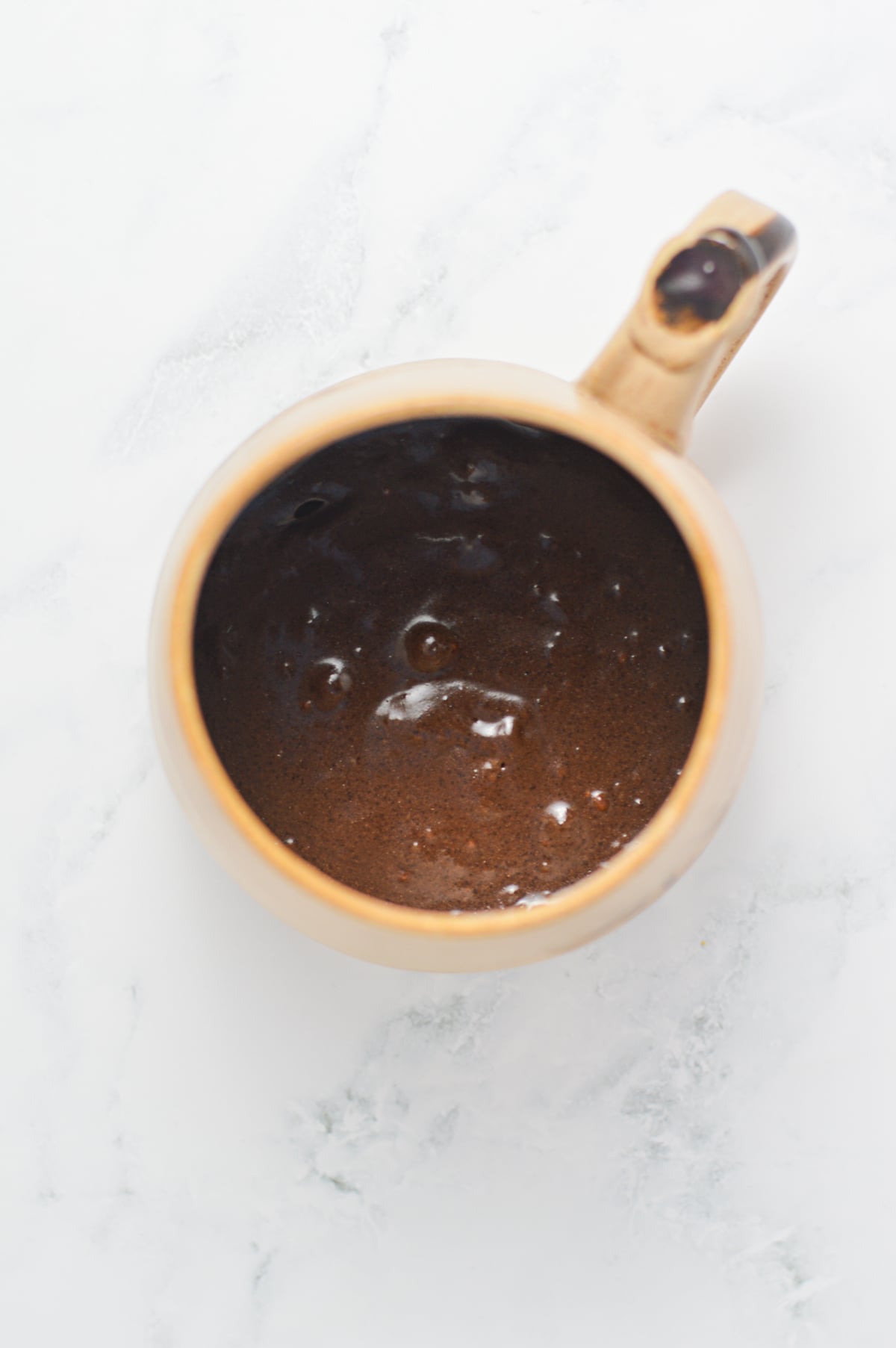 All of the ingredients for the 1 minute chocolate mug cake mixed together in a large coffee mug.