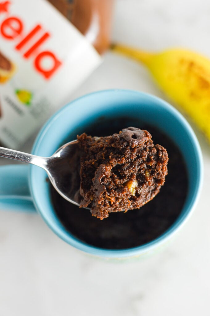 A spoonful of Banana Nutella Mug Cake, showing the fudgy texture of the warm cake.