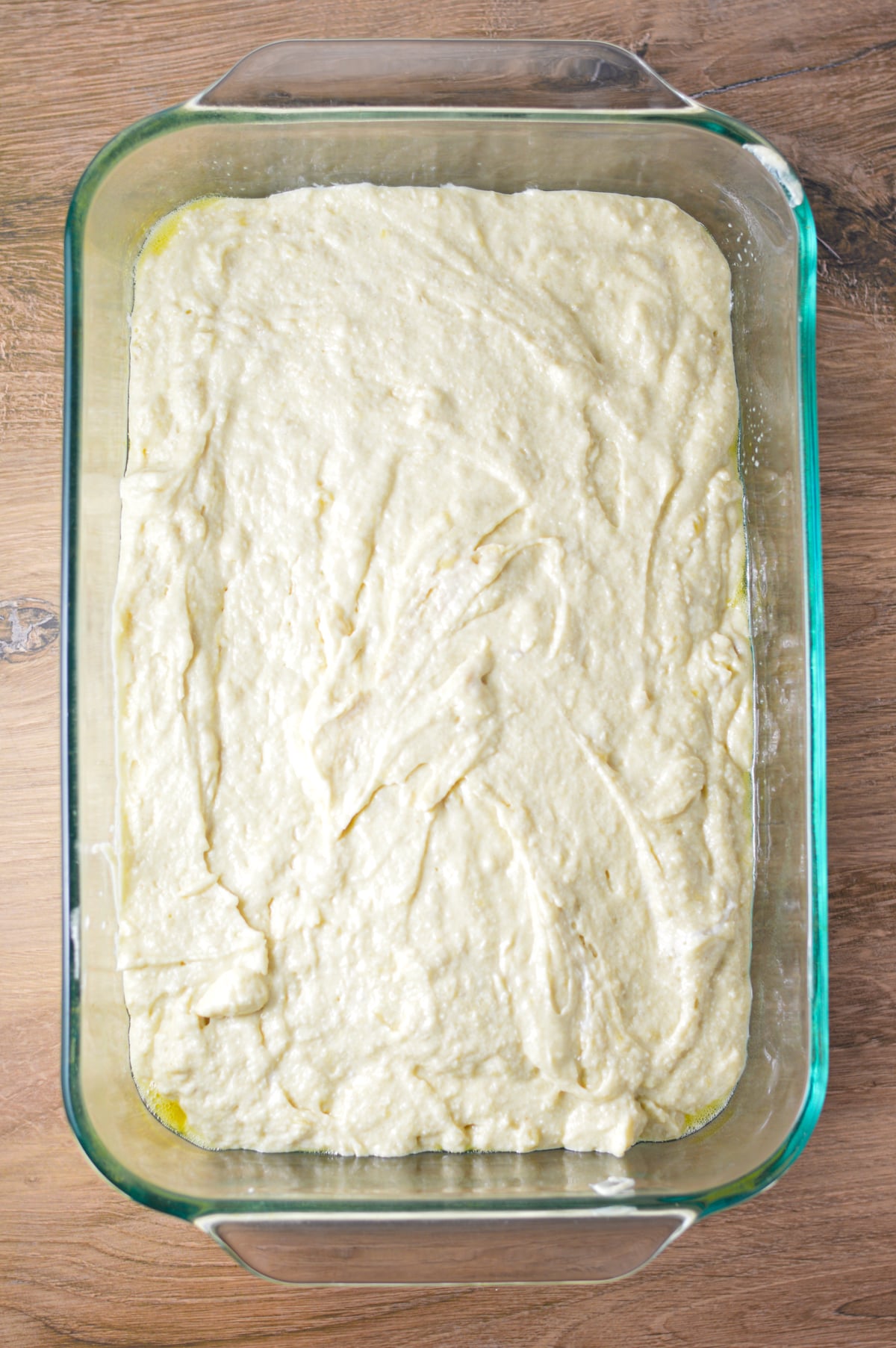 The banana cake batter poured into a glass 9x13 baking pan.