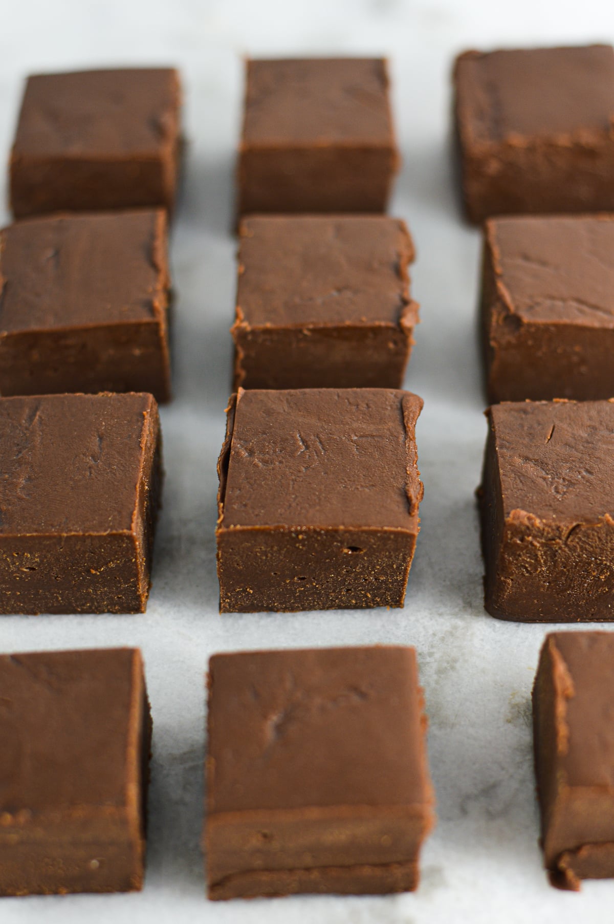 Slices of homemade 3-ingredient Nutella fudge arranged in a grid, showing off the smooth, creamy texture.