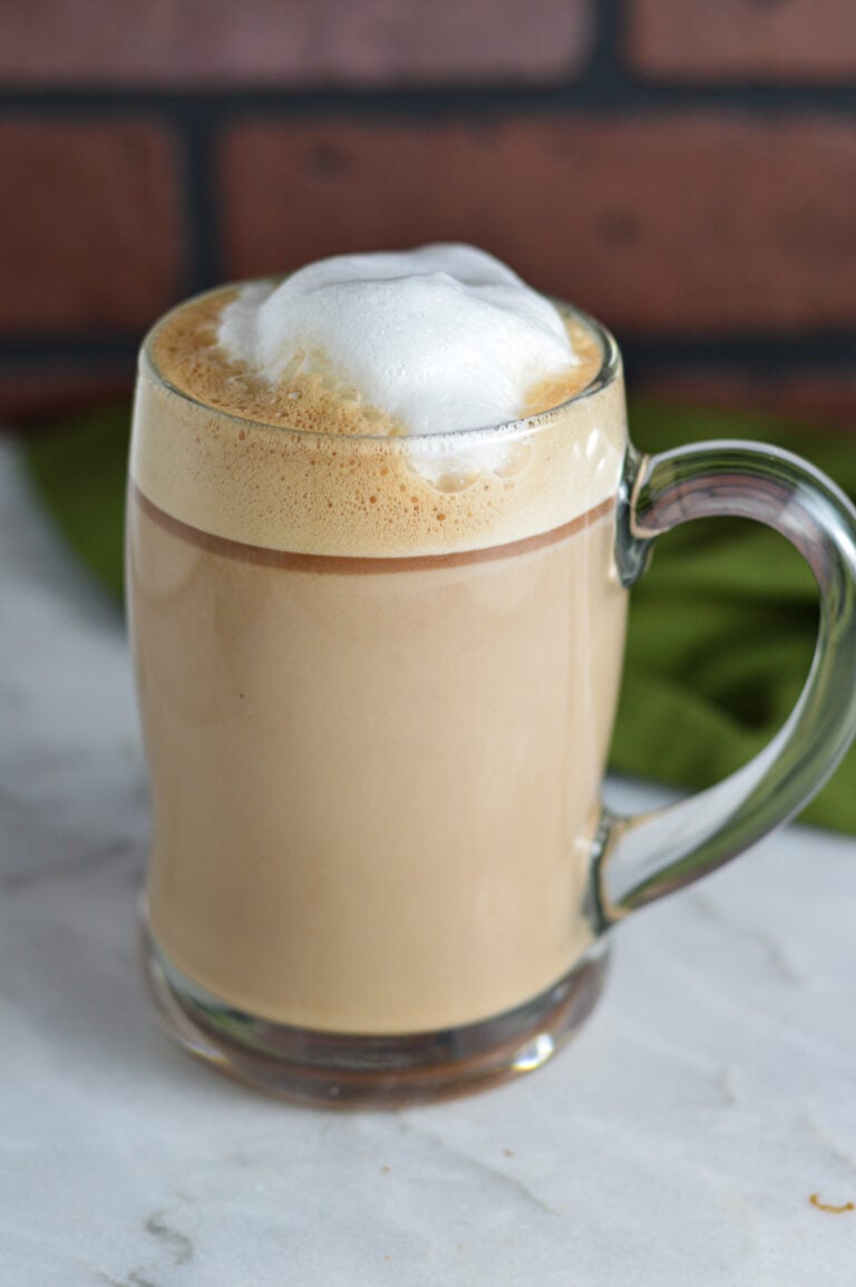 Nutella Latte with frothed milk on top on a granite surface.