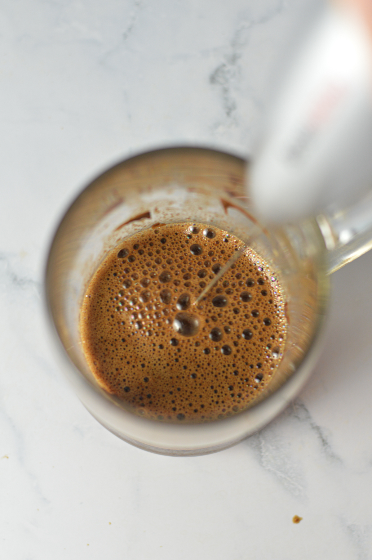 A milk frother mixing together ingredients for a Nutella Latte.