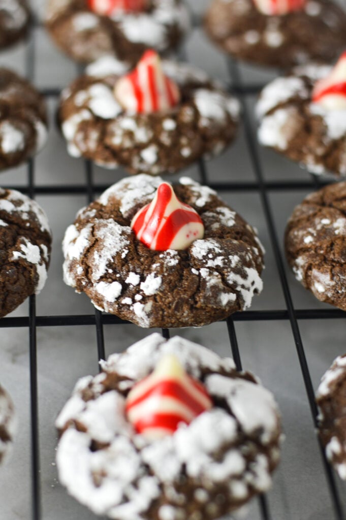 Peppermint Kiss Chocolate Crinkle Cookies arranged on a wire rack.