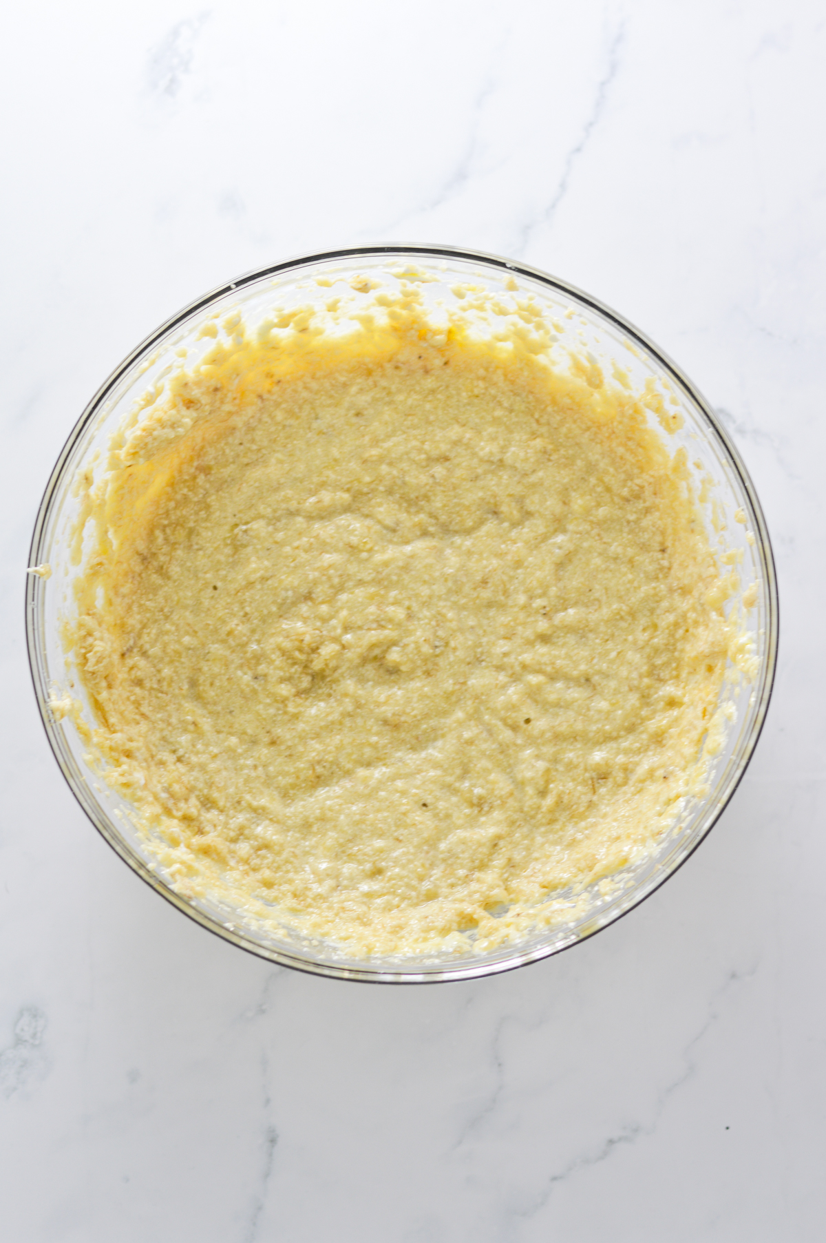 The wet ingredients of the triple chocolate banana muffins mixed together in a large glass bowl.