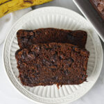 Two slices of Double Chocolate Banana Bread on a small white plate, showing the rich chocolatey texture.