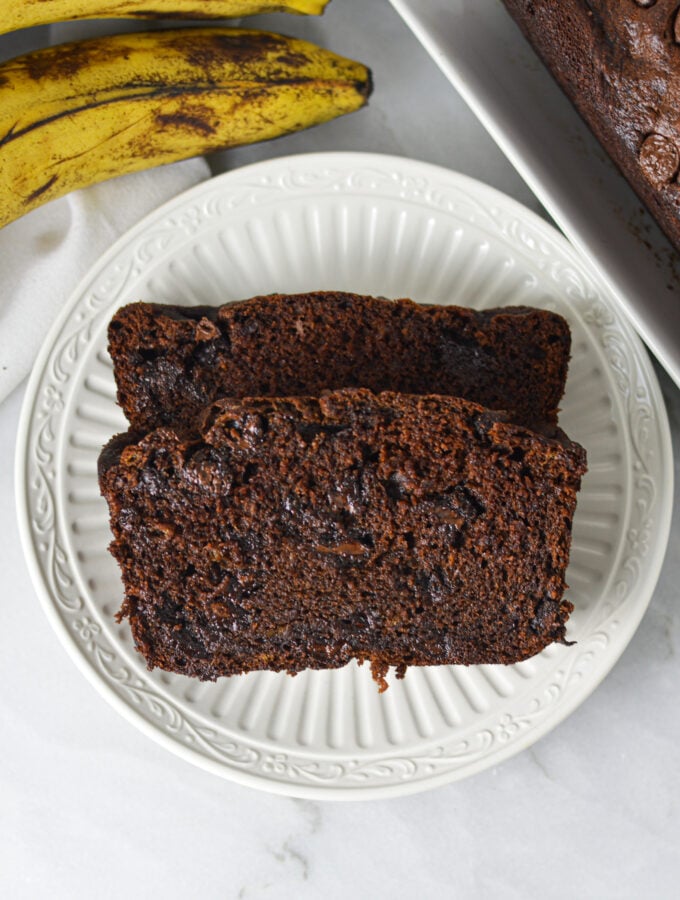 Two slices of Double Chocolate Banana Bread on a small white plate, showing the rich chocolatey texture.