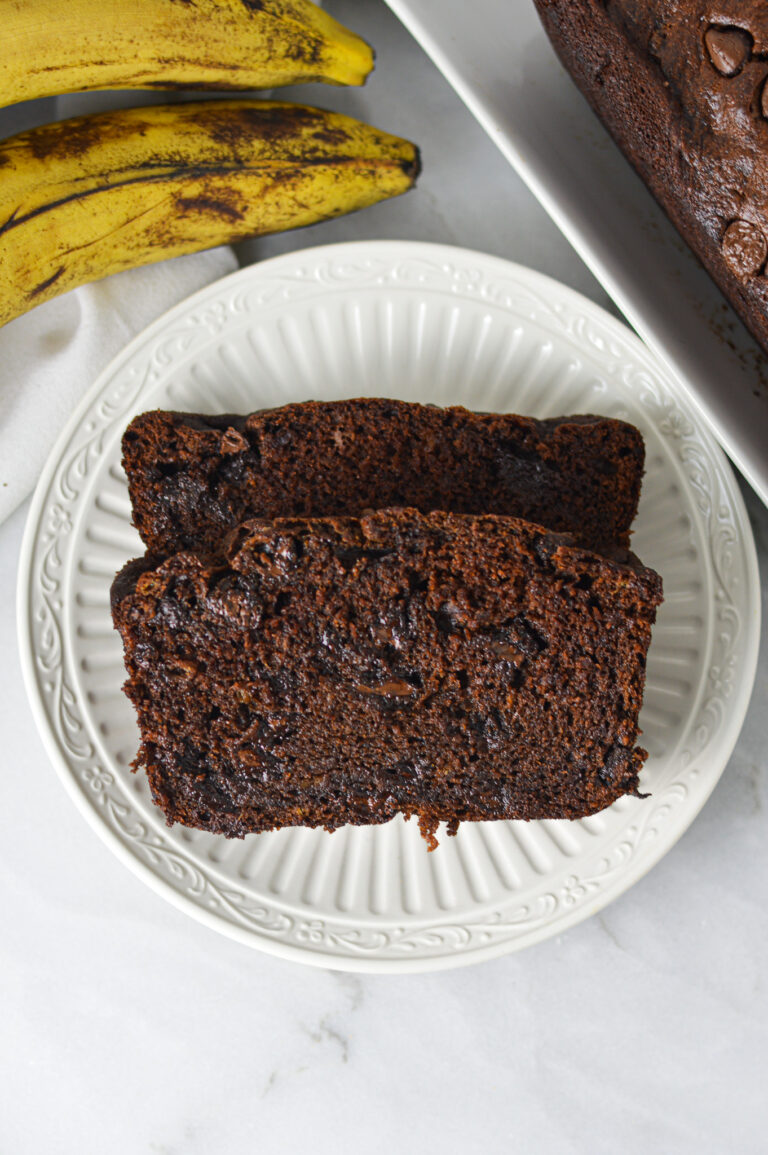 Two slices of Double Chocolate Banana Bread on a small white plate, showing the rich chocolatey texture.