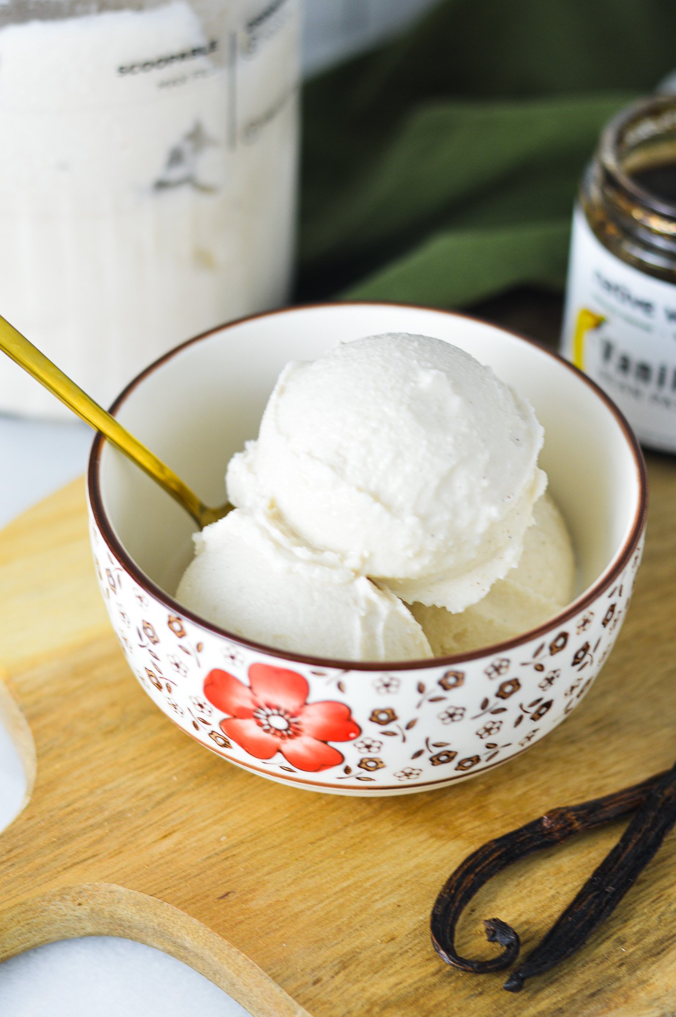 A bowl full of Ninja Creami Vanilla Bean Ice Cream, with a gold spoon sticking out of the bowl.