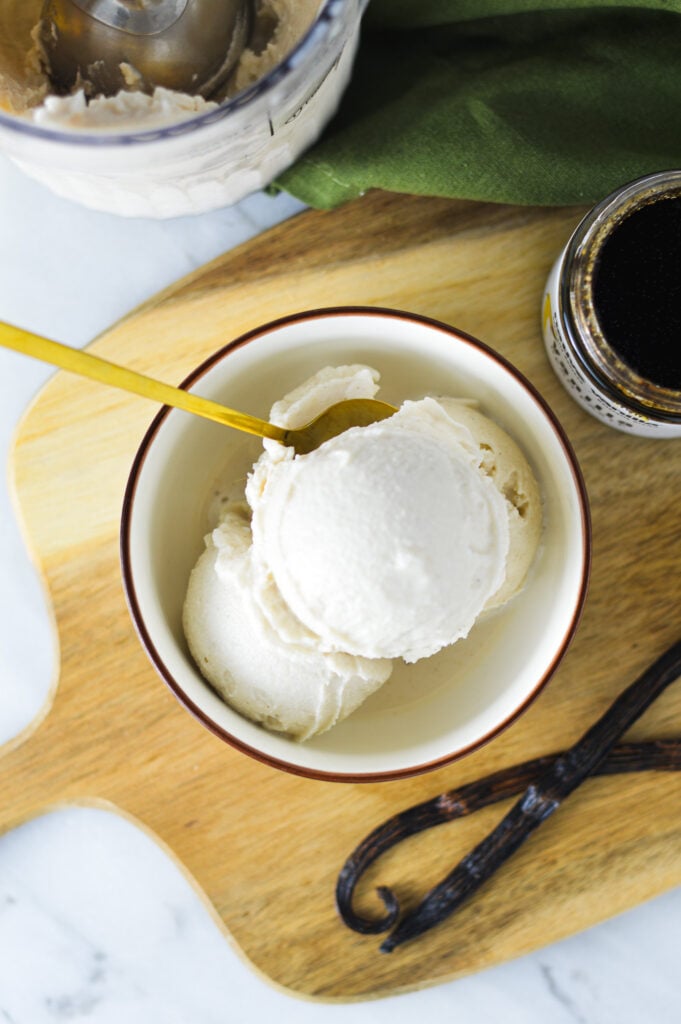 A spoon taking a scoop of Ninja Creami Vanilla Bean Ice Cream, showing the vanilla flecks inside the creamy ice cream.