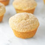A batch of cake-like Donut Muffins arranged neatly on a granite surface.