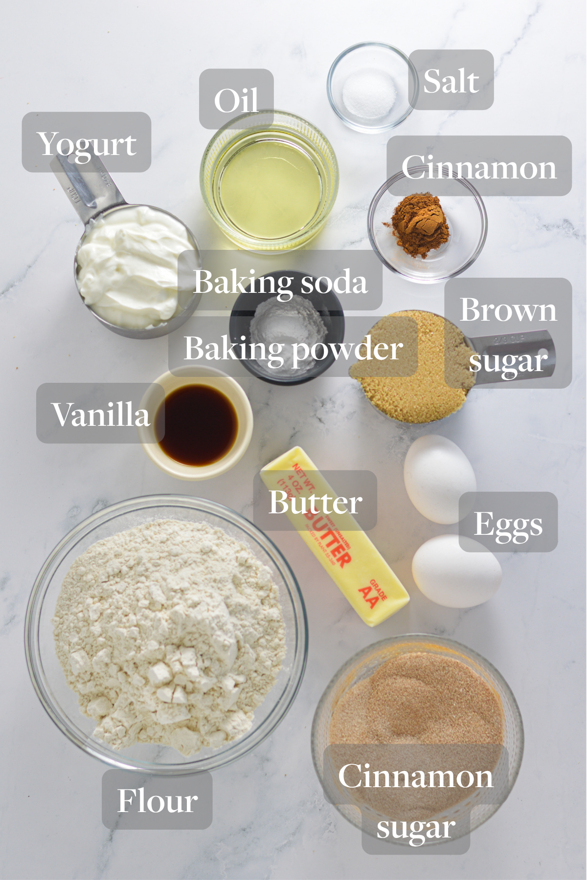 All of the ingredients needed to make Donut Muffins laid out on a granite surface.