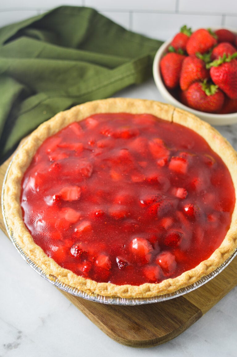 A homemade Strawberry Pie with chunks of strawberry in the glossy filling inside the golden brown flaky crust.