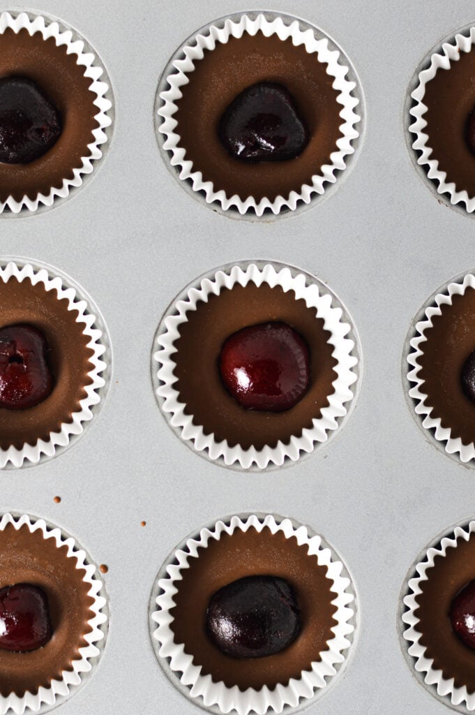 A mini muffin pan filled with Cherry Nutella Cups in paper liners.
