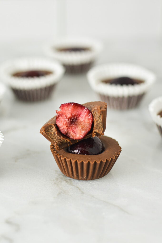 A stack of Cherry Nutella Cups with a bite taken out of the top one showing the bright red center of the cherry.