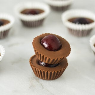 A stack of Cherry Nutella Cups on a granite surface, with more creamy Nutella cups in the background.