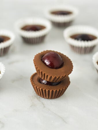 A stack of Cherry Nutella Cups on a granite surface, with more creamy Nutella cups in the background.