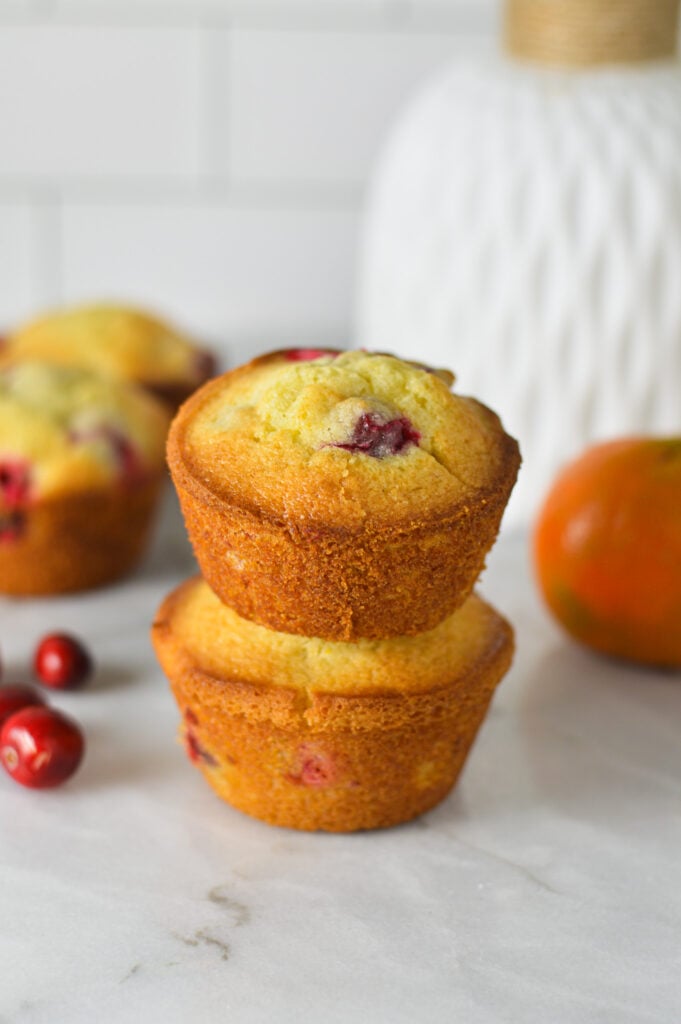 A stack of homemade Cranberry Orange Muffins, with the sides perfectly golden brown.