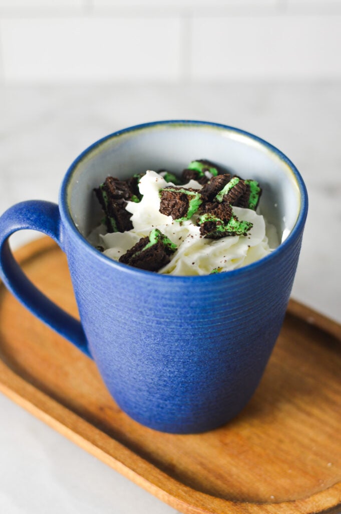 A decadent cup of Mint Oreo Hot Chocolate, topped with homemade whipped cream and mint Oreo cookie crumbs.