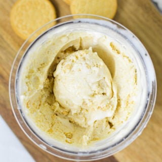 A Ninja Creami pint container filled with Ninja Creami Golden Oreo Ice Cream, with an ice cream scoop resting on top.