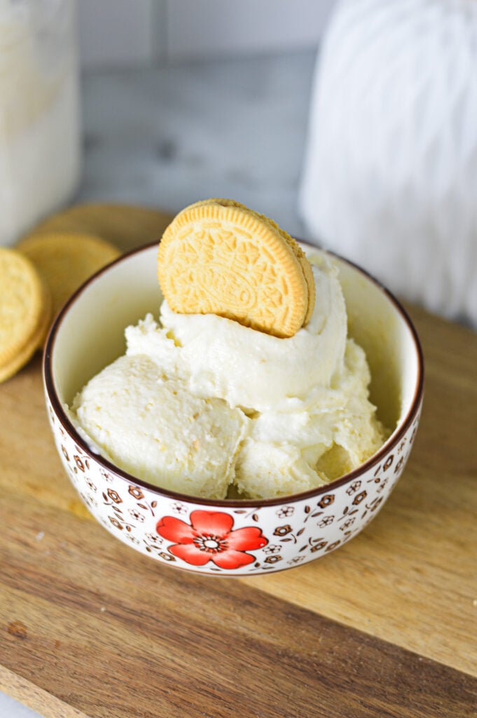 A small bowl filled with Ninja Creami Golden Oreo Ice Cream, with a crunchy Golden Oreo on top of the ice cream.