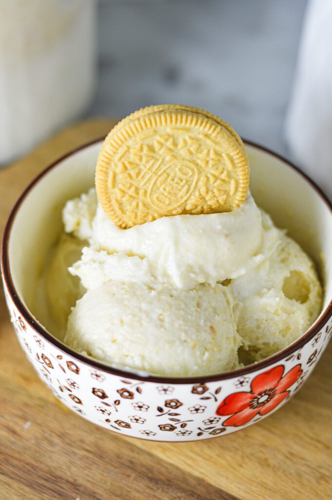 A bowl of Ninja Creami Golden Oreo Ice Cream, with a whole Oreo cookie on top of the creamy ice cream.