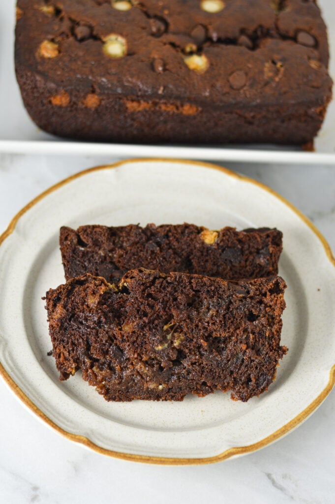 2 thick slices of Triple Chocolate Banana Bread with the white and semi-sweet chocolate chips studded on top of the dark brown bread.