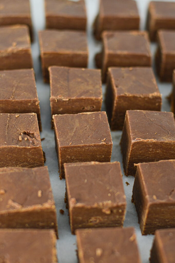 Squares of Peanut Butter Chocolate Fudge arranged on a granite surface.