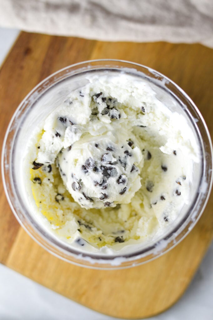 A Ninja Creami Container filled with creamy ice cream dotted with mini chocolate chips.