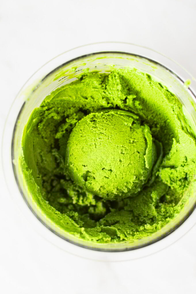 A Ninja Creami Pint container filled with Ninja Creami Matcha Ice Cream, with a creamy scoop on top showing the rich texture.