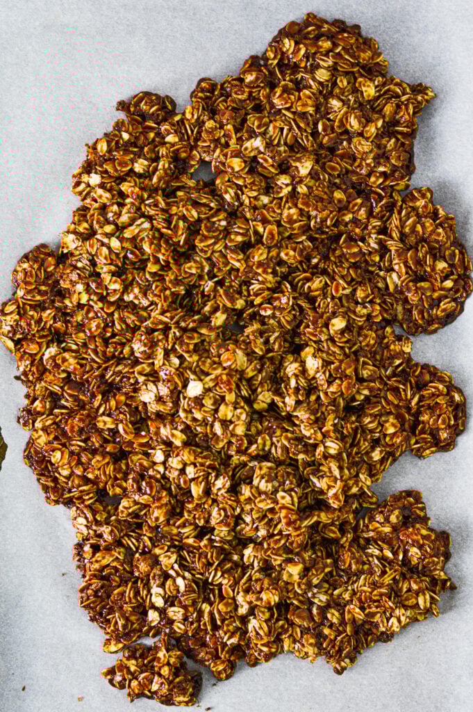 A parchment paper lined baking sheet with Nutella Granola that has not been broken up yet.
