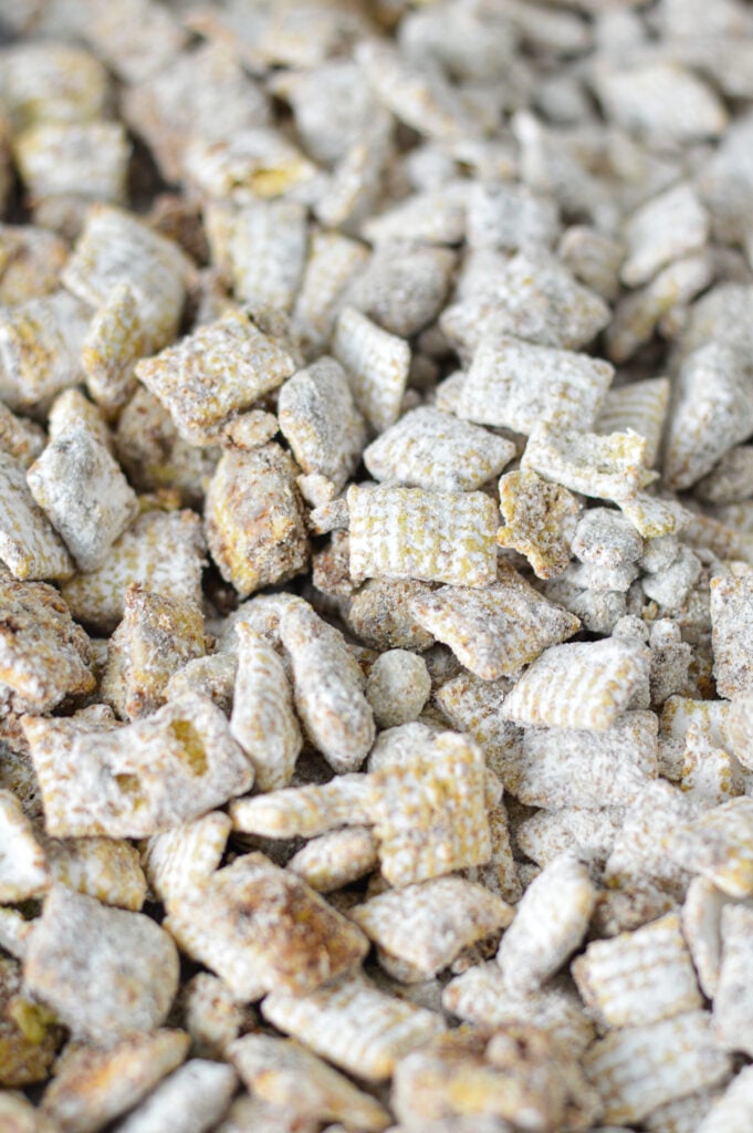 A parchment paper lined baking sheet with freshly made Nutella Muddy Buddies.