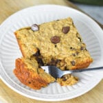A fork taking a piece of the homemade Peanut Butter Chocolate Chip Baked Oatmeal, showing the hearty texture of the oatmeal.