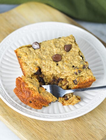 A fork taking a piece of the homemade Peanut Butter Chocolate Chip Baked Oatmeal, showing the hearty texture of the oatmeal.
