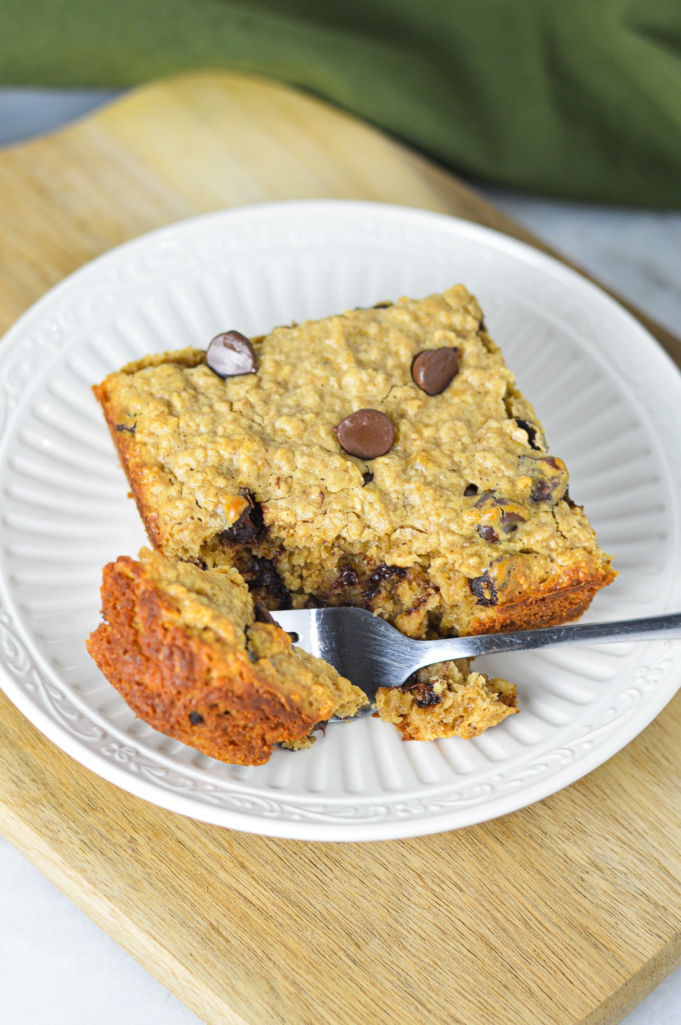 A fork taking a piece of the homemade Peanut Butter Chocolate Chip Baked Oatmeal, showing the hearty texture of the oatmeal.