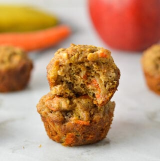 A stack of ABC Baby Mini Muffins, with a bite taken out of the top muffin showing the soft texture.