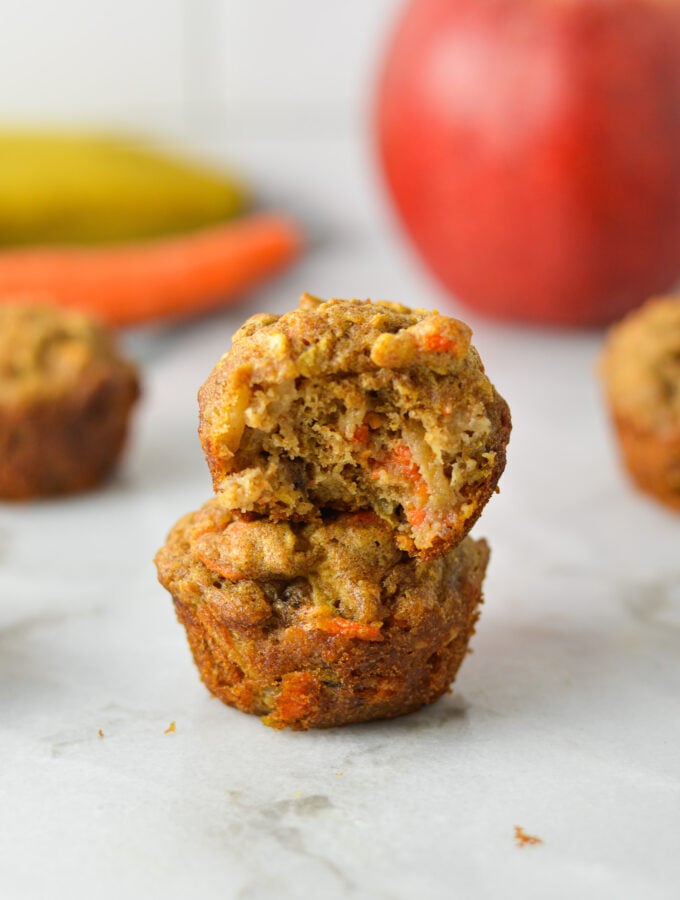 A stack of ABC Baby Mini Muffins, with a bite taken out of the top muffin showing the soft texture.