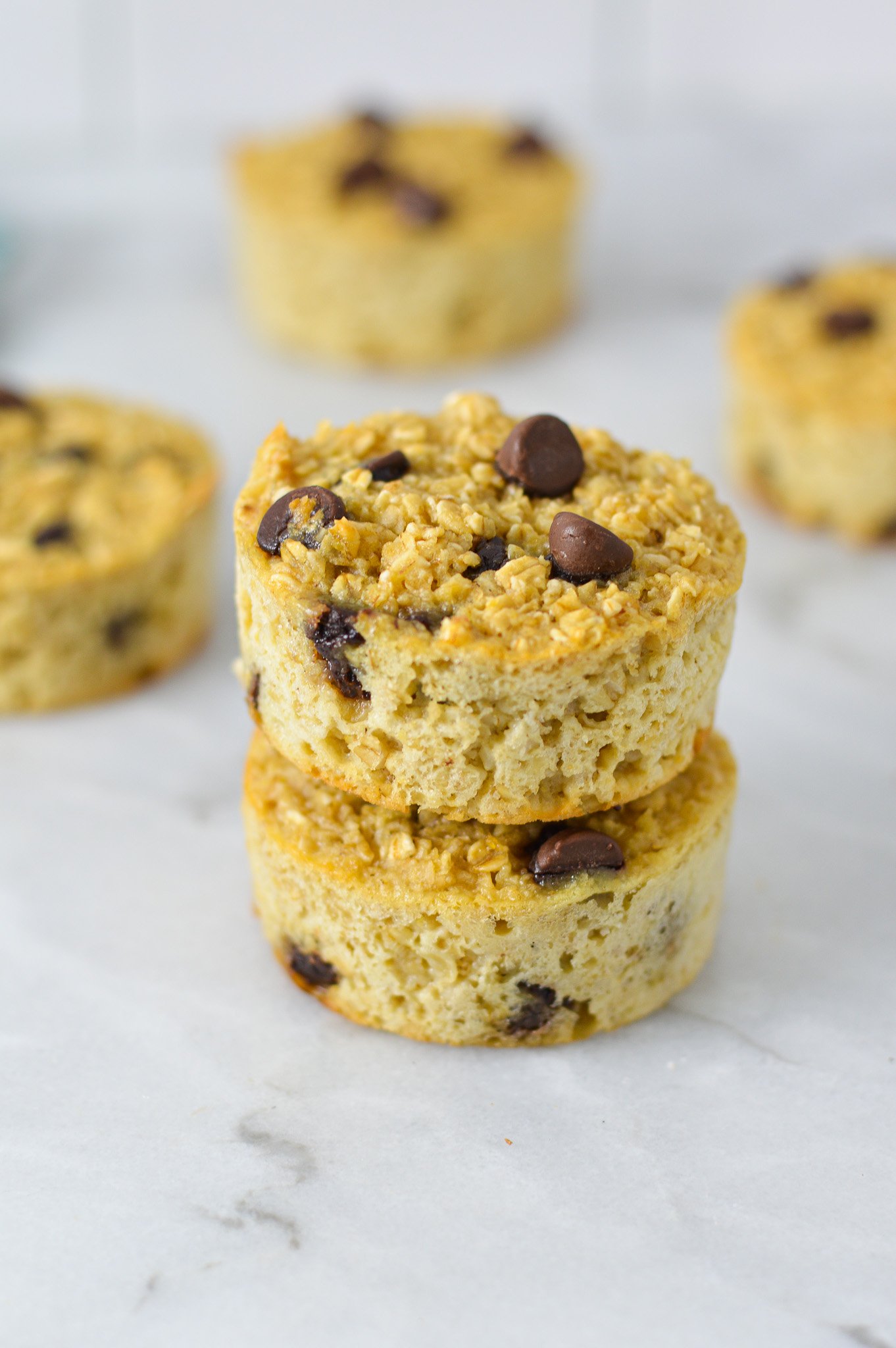 A stack of Chocolate Chip Baked Oatmeal Cups, with the rich chocolate chips sticking out of the nutritious oatmeal cups.