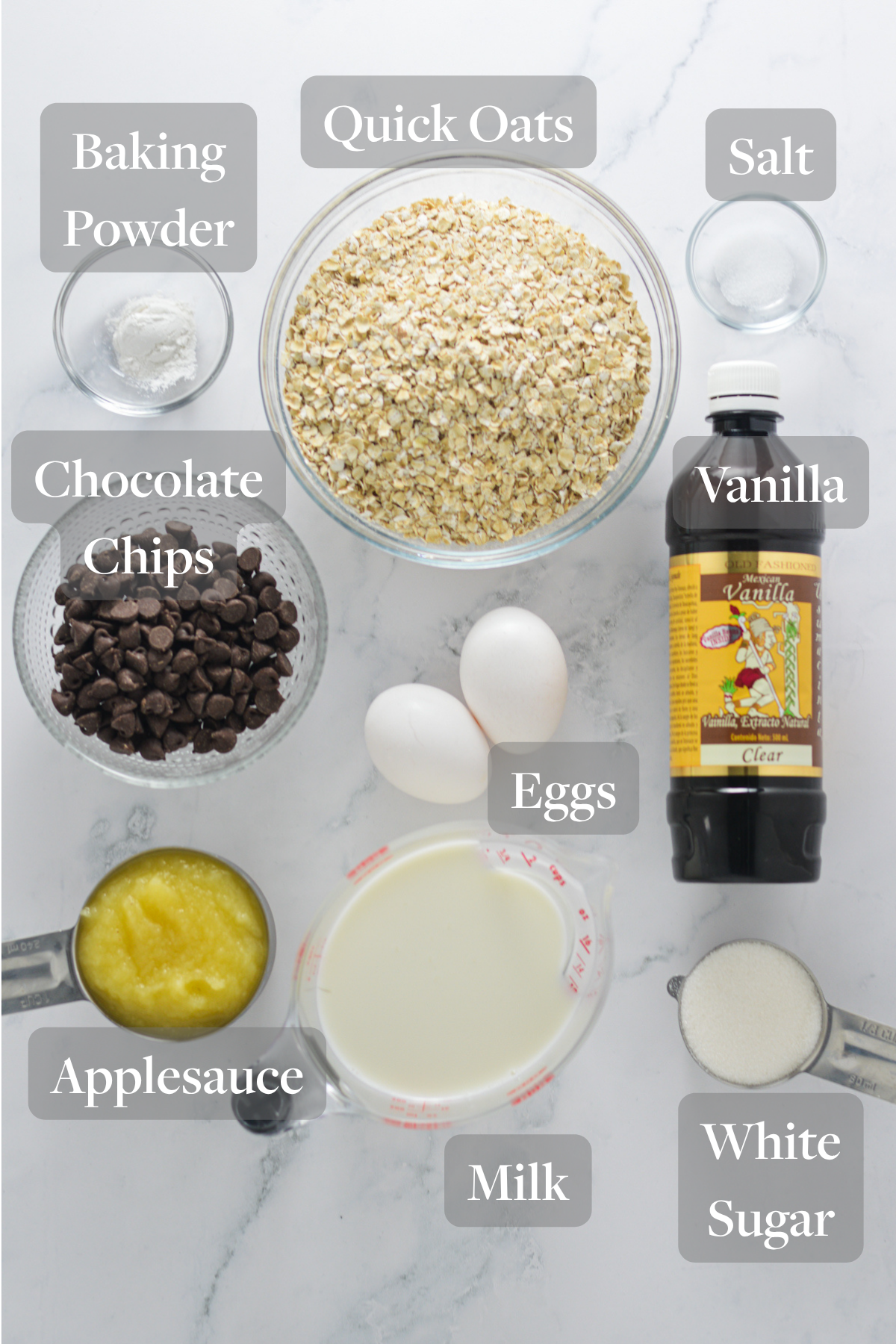 All the ingredients you need to make Chocolate Chip Baked Oatmeal Cups laid out on a granite surface.