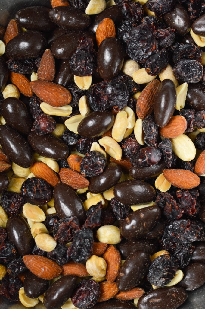 A closeup of homemade Cranberry Chocolate Almond Trail Mix, with the nut and fruit mixture shining in the light.