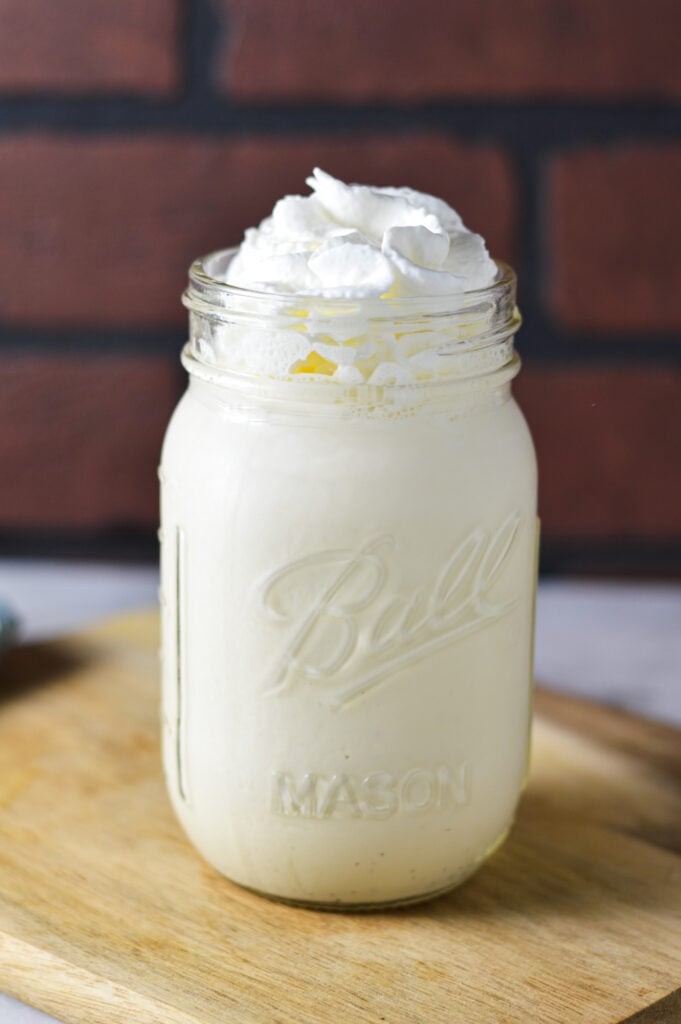 Ninja Creami Vanilla Bean Milkshake in a mason jar, topped with whipped cream.