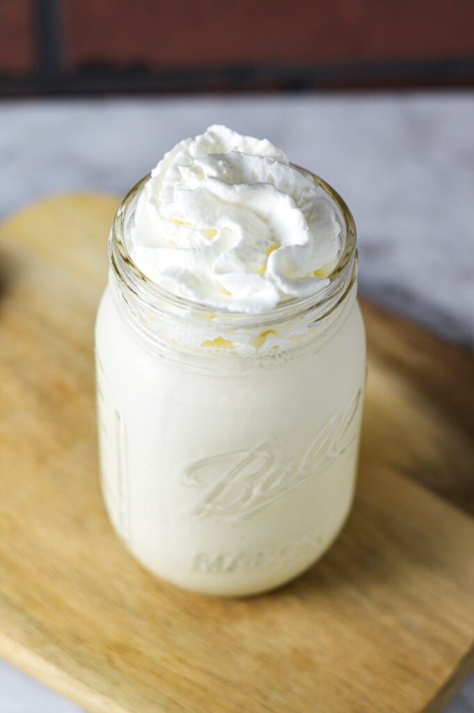 Ninja Creami Vanilla Bean Milkshake in a glass jar, topped with whipped cream.