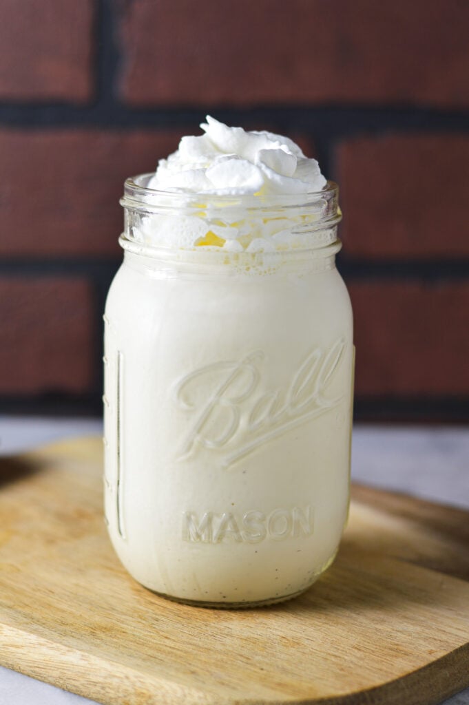 Creamy vanilla bean milkshake made in the Deluxe Ninja Creami machine, topped with whipped cream.