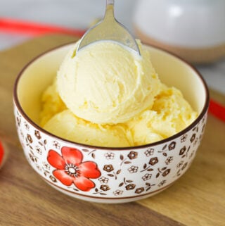 A bowl of Ninja Creami Eggnog Ice Cream, with a spoon sticking out of the festive dessert.